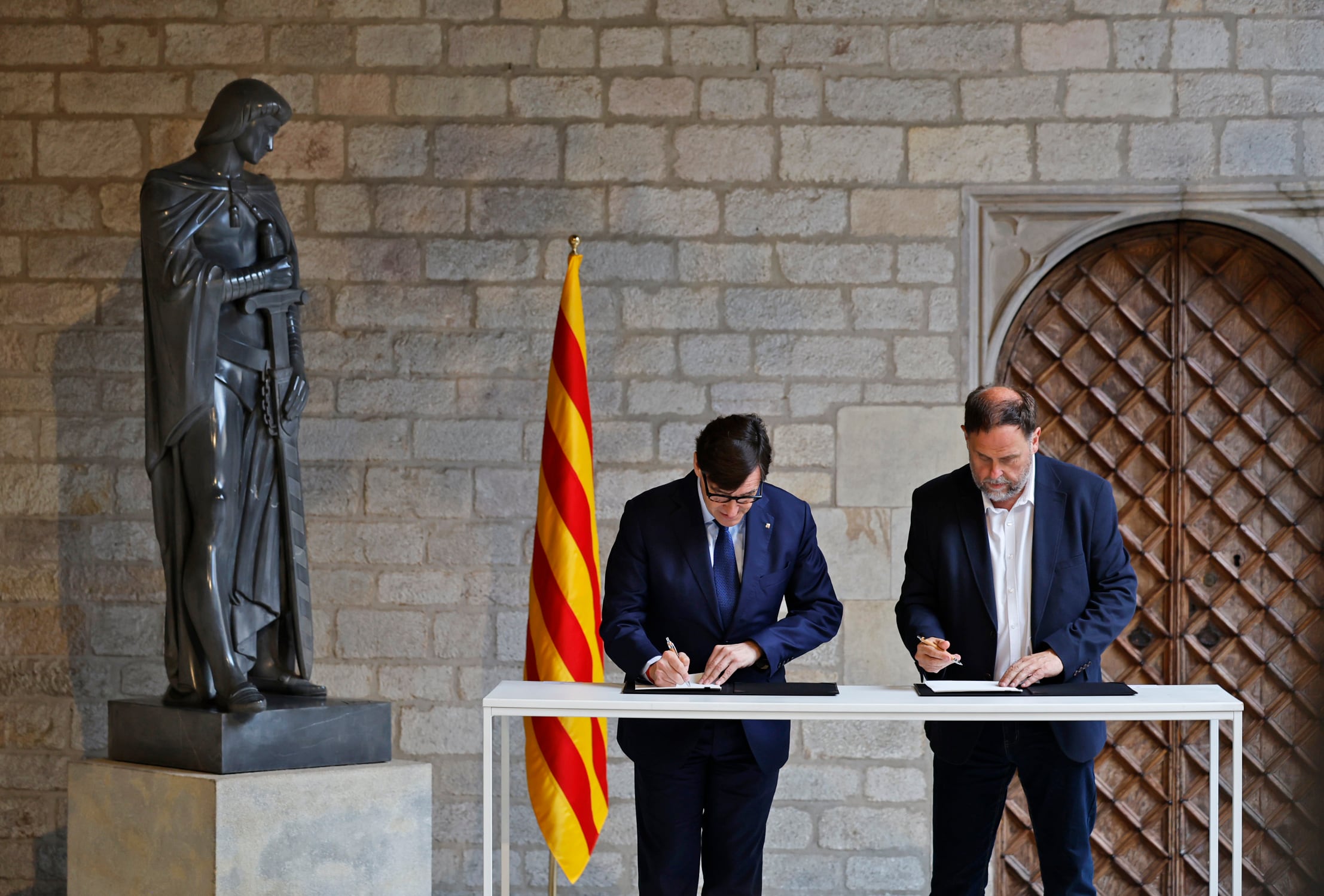 El presidente de la Generalitat, Salvador Illa, y el presidente de ERC, Oriol Junqueras, firman el acuerdo para los Presupuestos catalanes de 2026.