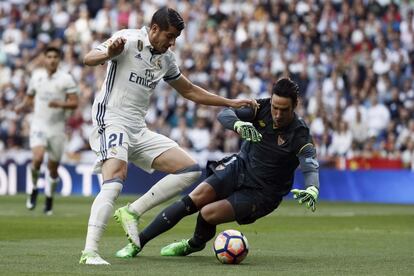 El delantero del Real Madrid, Álvaro Morata (i), intenta superar al guardameta del Sevilla, Sergio Rico.