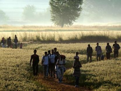 Inmigrantes se dirigen a cruzar la frontera entre Grecia y Macedonia, en agosto de 2015.