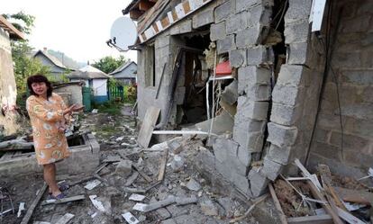 Una vecina de Donetsk muestra su casa destruida por los combates.