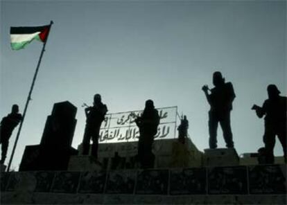 Milicianos de las Brigadas de los Mártires de Al Aqsa vigilan desde la azotea del Parlamento palestino en Gaza.