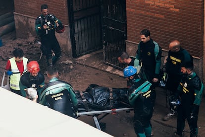 Agentes de los bomberos y la Guardia Civil rescataban este sábado un cuerpo un aparcamiento de Benetússer.