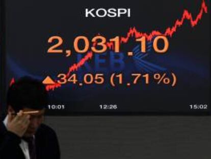 Un empleado surcoreano de la Bolsa de Seúl trabaja junto a un monitor que muestra el índice referencial del Kospi. EFE/Archivo
