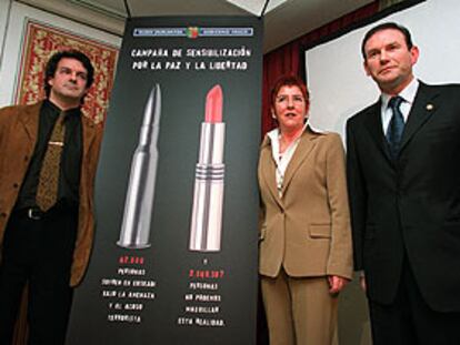 Urquijo, Lasa e Ibarretxe, ayer en Madrid ante el cartel de la campaña de apoyo a las víctimas de ETA.