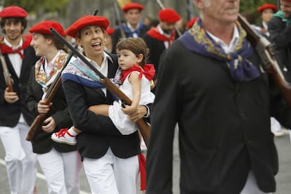 Una componente de la compañia Jaizkibel llevando a su hija al final del desfile.