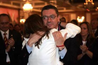 El alcalde Alberto Ruiz-Gallardón abraza a su esposa, Mar Utrera, tras producirse la eliminación de Madrid. A la derecha, la concejal socialista Trinidad Jiménez.