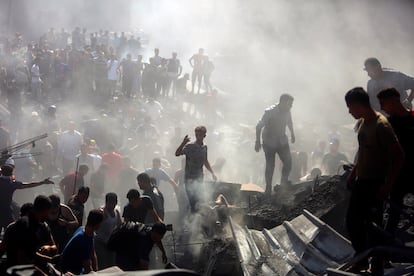 Palestinos buscan supervivientes entre los escombros de un edificio derruido, a causa de un ataque israelí, este jueves en Jan Yunis. 