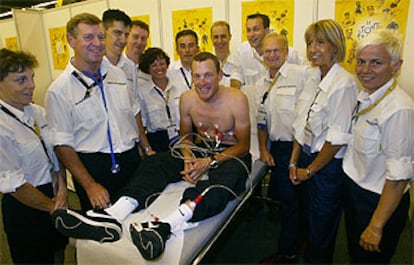 Lance Armstrong posa en la camilla junto al equipo médico que le hizo el reconocimiento previo a la carrera.