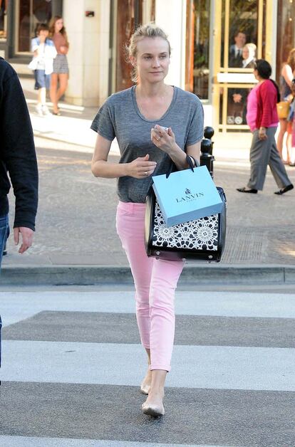 Hemos escogido este outfit de Diane Kruger por la tendencia de los pantalones en tonos pastel.  Nos encanta la combinación de camiseta gris con los vaqueros rosa palo. El bolso estampado es de Alexander McQueen y las bailarinas de Phillip Lim.
