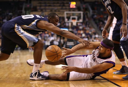 Dudley intenta pasar el balón, sujetado por Darrel Arthur, de Memphis Grizzlies