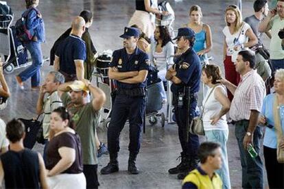 Dos agentes del Cuerpo Nacional de Policía vigilan ayer un vestíbulo del aeropuerto de El Prat.