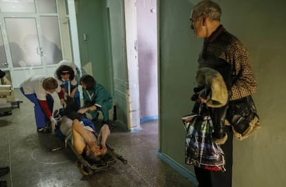 Tres sanitarias atienden en un hospital a un hombre herido, este domingo en la localidad ucrania de Artemivsk.