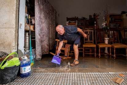 Un vecino del barrio de San Ginés de Cartagena (Murcia) retira el agua de su garaje, este martes.