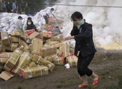 Una mujer se aleja del humo tóxico producido al mojarse productos químicos almacenados en la ciudad de Leigu (Sichuan).