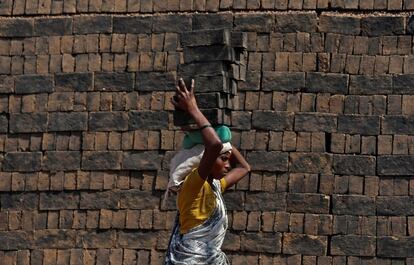 Una mujer lleva ladrillos en la cabeza, a las afueras de Bombay (India).