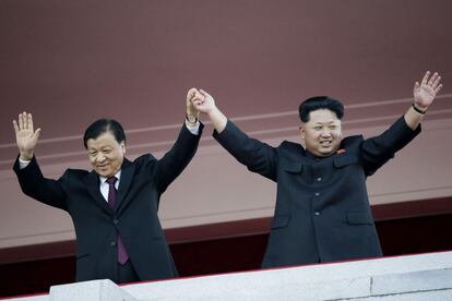 El líder norcoreano Kim Jong Un, a la derecha, y el dirigente del partido comunista chino, Liu Yunshan, de visita en Pyongyang, saludan durante el desfile.