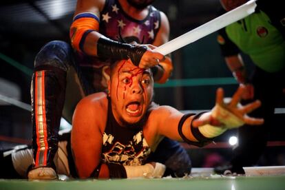 El luchador conocido como Gio Malkriado (parte superior) pelea contra Ciclope, durante una lucha libre extrema, dentro de un centro de lavado de coches, en Tulancingo Hidalgo (México).