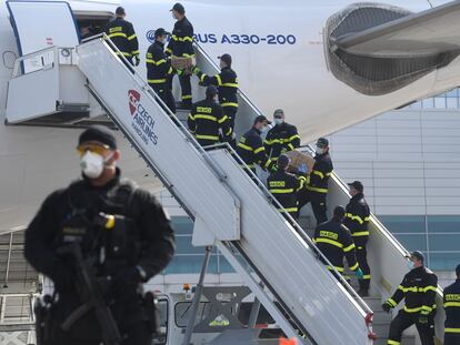 Un equipo de bomberos en Praga descarga cajas con material protector enviado por China