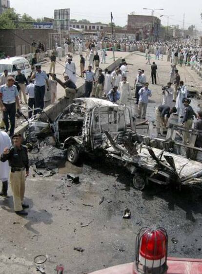 Las fuerzas de seguridad de Pakistán examinan el lugar del atentado de esta mañana en Penshawar en el que han muerto 14 soldados.