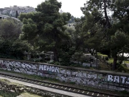 Dos jardineros en las ruinas del Agora romana con la Acr&oacute;polis al fondo. 