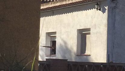 El hombre atrincherado apunta con una carabina desde la ventana.