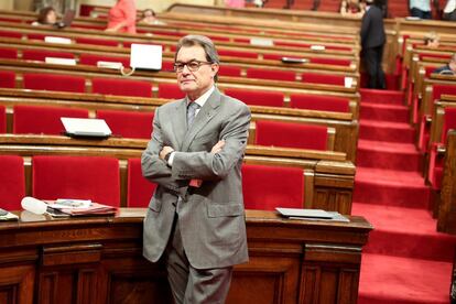 El presidente Artur Mas espera el reinicio del debate en el hemiciclo casi vacio.