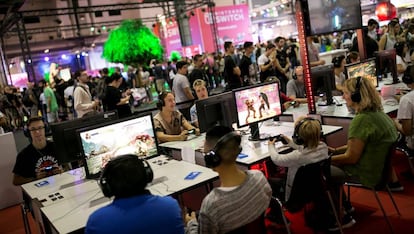 Jóvenes juegan a videojuegos en el marco de la feria anual del sector en España, organizada por Aevi en Barcelona.