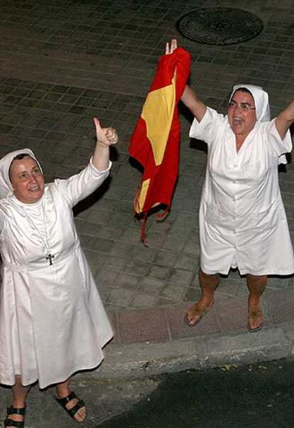 Dos monjas saludan a la seleccion española de baloncesto. Los aficcionados se han volcado con el equipo de Pepu Hernández y han esperado su llegada durante horas para brindarles un un homenaje a la altura del éxito conseguido.