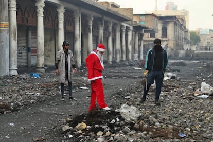 Un manifestante se viste de Papá Noel cerca de las barreras establecidas por las fuerzas de seguridad para cerrar la calle Rasheed durante las continuas protestas contra el Gobierno en Bagdad (Irak).