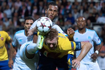 El centrocampista togolés del Marsella Jacques-Alaixys Romao levanta la pierna ante Mertesacker para llevarse el balón.