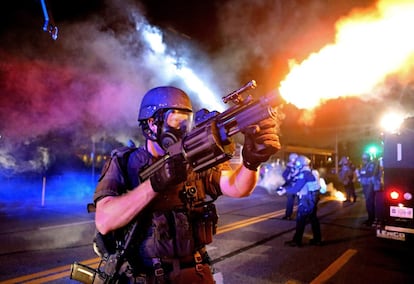 St. Louis Post-Dispatch recibió un Pulitzer por sus fotografías de los disturbios ocurridos en Ferguson, en Misuri, tras la muerte de un joven negro a manos de un policía blanco que provocaron una ola de protestas en todo el país. En la imagen, un miembro de la policía de St. Louis lanza botes de gases lacrimógenos contra una multitud durante las manifestaciones en Ferguson (EE UU), el 18 de agosto de 2014.