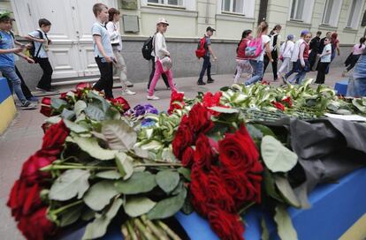 Numerosos niños caminan junto a flores colocadas como homenaje a las víctimas del ataque de Mánchester, frente a la Embajada del Reino Unido en Kiev (Ucrania).
