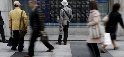 Peatones ante un panel de cotizaciones en Tokio. 