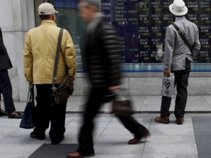 Peatones ante un panel de cotizaciones en Tokio. 