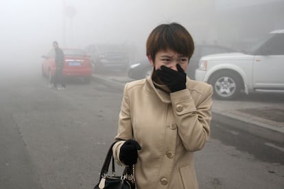 Una mujer camina por una de las calles de Harbin (China). "Muchos ciudadanos de Harbin pensaron que había nevado porque las ventanas estaban completamente blancas", señaló el canal estatal CCTV, mientras algunos internautas aconsejan en redes sociales que los empleados se tomen el día libre.