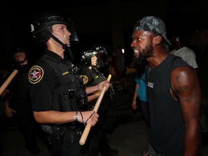 Un hombre enfrenta a un policía, en las protestas en Kenosha, Wisconsin.