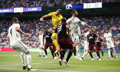 El jugador del Real Madrid Sergio Ramos trata de cabecear el balón ante la salida del portero del MIlan.