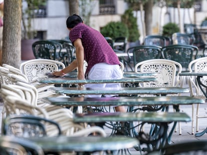 Empleado de un bar limpiando una de las mesas, en Madrid.