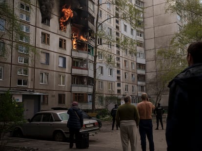 Unos vecinos observaban los daños en un edificio tras un ataque ruso, este lunes en Járkov.