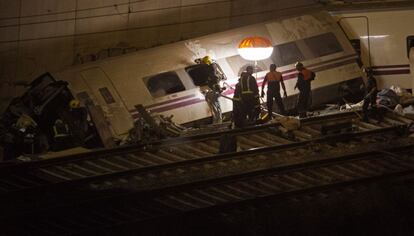 Un bombero entra en uno de los vagones descarrilados, 25 de julio de 2013. La cifra oficial de fallecidos en el siniestro continúa en 77, 73 de los cuales fueron recuperados en las vías del tren y otros cuatro murieron en el hospital.