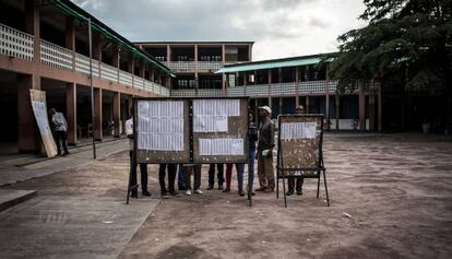 Un grupo de personas revisan las listas del censo en un colegio electoral de Kinshasa.