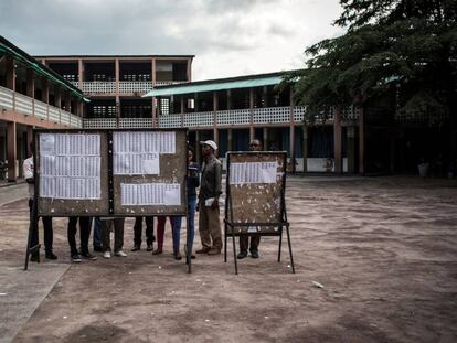 Un grupo de personas revisan las listas del censo en un colegio electoral de Kinshasa.