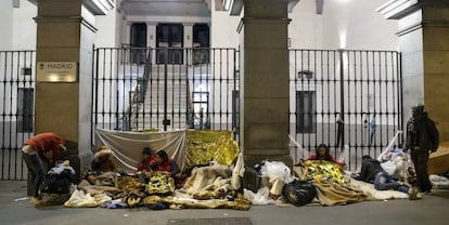 Un grupo de solicitantes de asilo se dispone a pasar la noche frente a la sede del Samur Social, en el centro de Madrid.