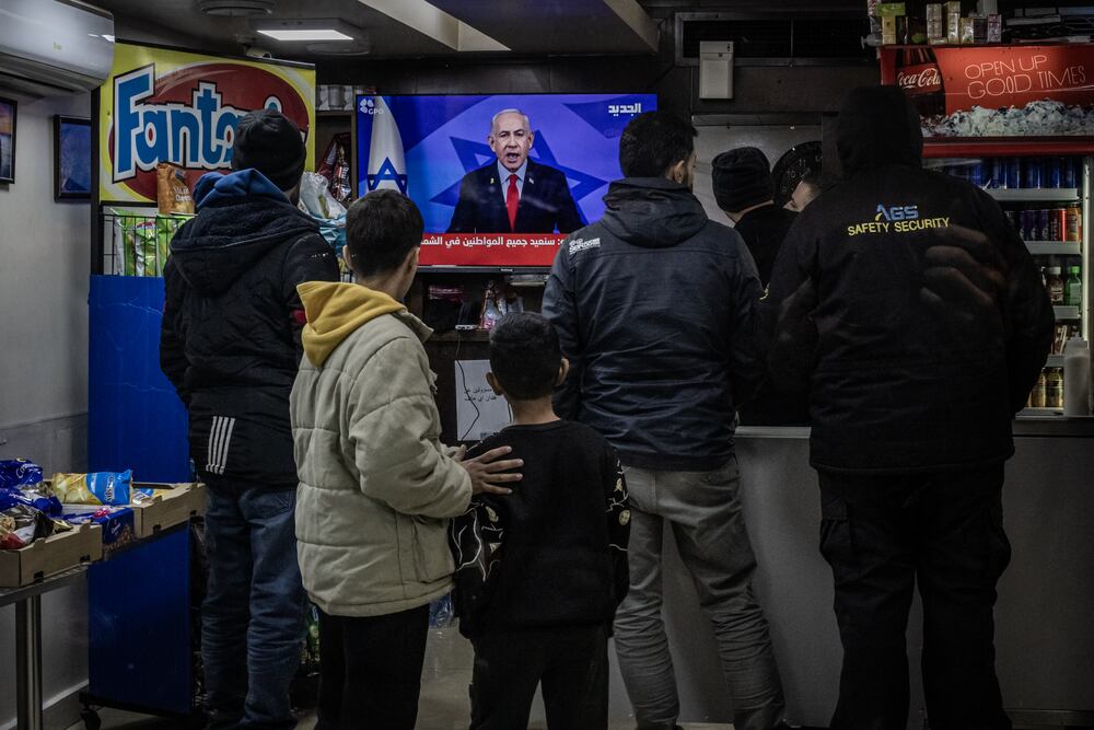 BEIRUT, LEBANON - NOVEMBER 26: People watch television as Prime Minister Benjamin Netanyahu announces a ceasefire near Martyrs Square where people sheltered as Israeli battered central Beirut with multiple airstrikes on November 26, 2024 in Beirut Lebanon. Prime Minister Benjamin Netanyahu made a statement on Tuesday, confirming that the Israeli security cabinet approved a proposed ceasefire agreement with Hezbollah, the Iran-backed Lebanese militant group. The two sides have been trading cross-border fire since October 2023, following the Hamas attacks on Israel, and Israel's subsequent incursions into Gaza and southern Lebanon. (Photo by Ed Ram/Getty Images)