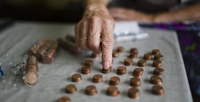 Una mujer mayor cuenta monedas. 