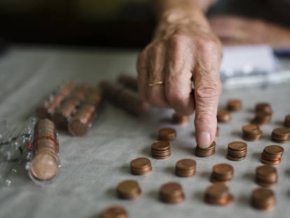 Una mujer mayor cuenta monedas. 