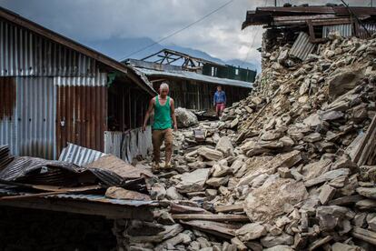 Sete Tamang, camina sobre las ruinas de las calles de su pueblo, tras varios años sin visitarlo, trabajando como operario en una fábrica en Malasia.