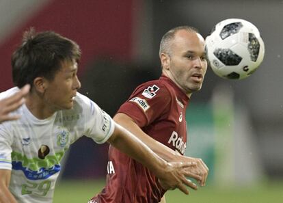 Andrés Iniesta (derecha) lucha por el balón.