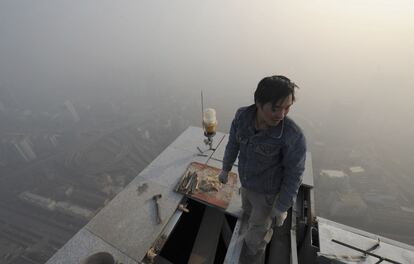 Un obrero trabaja en lo alto de un edificio en la provincia de Anhui.