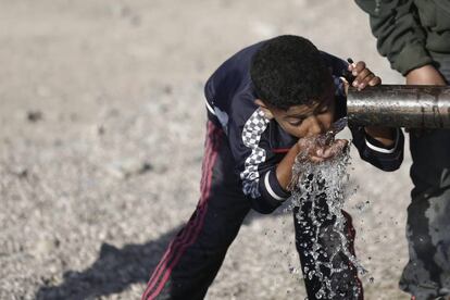Un ni&ntilde;o refugiado toma agua de una tuber&iacute;a en Idomeni, cerca la frontera de Grecia con Macedonia, el 20 de abril de 2016.